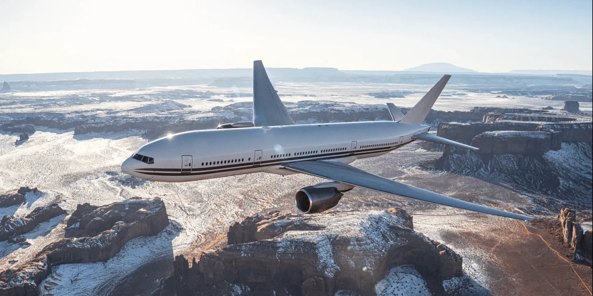 Boeing 777-200ER flying over table top mountains